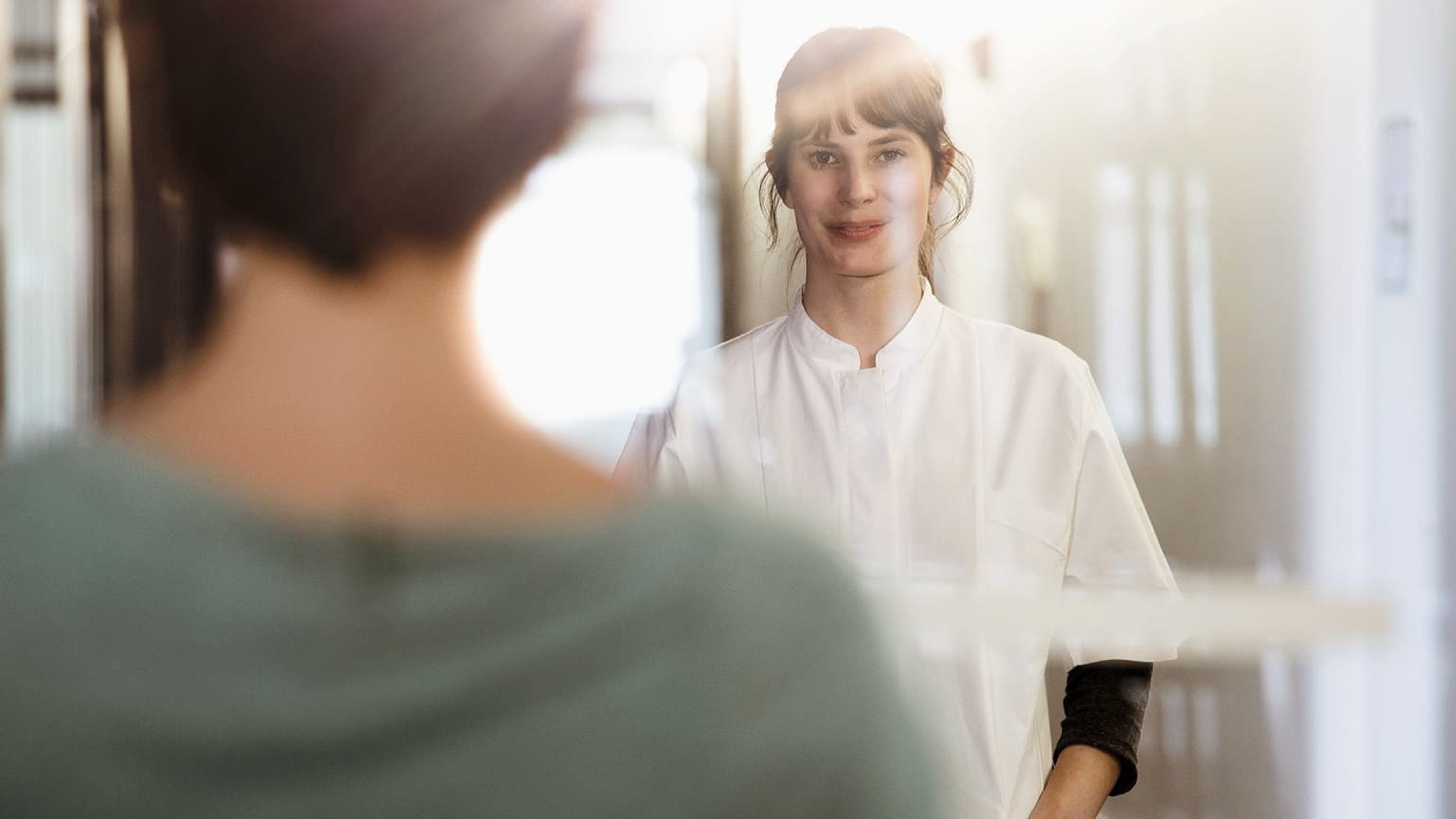 Krankenschwester im Krankenhaus im Flur mit Blick in die Kamera