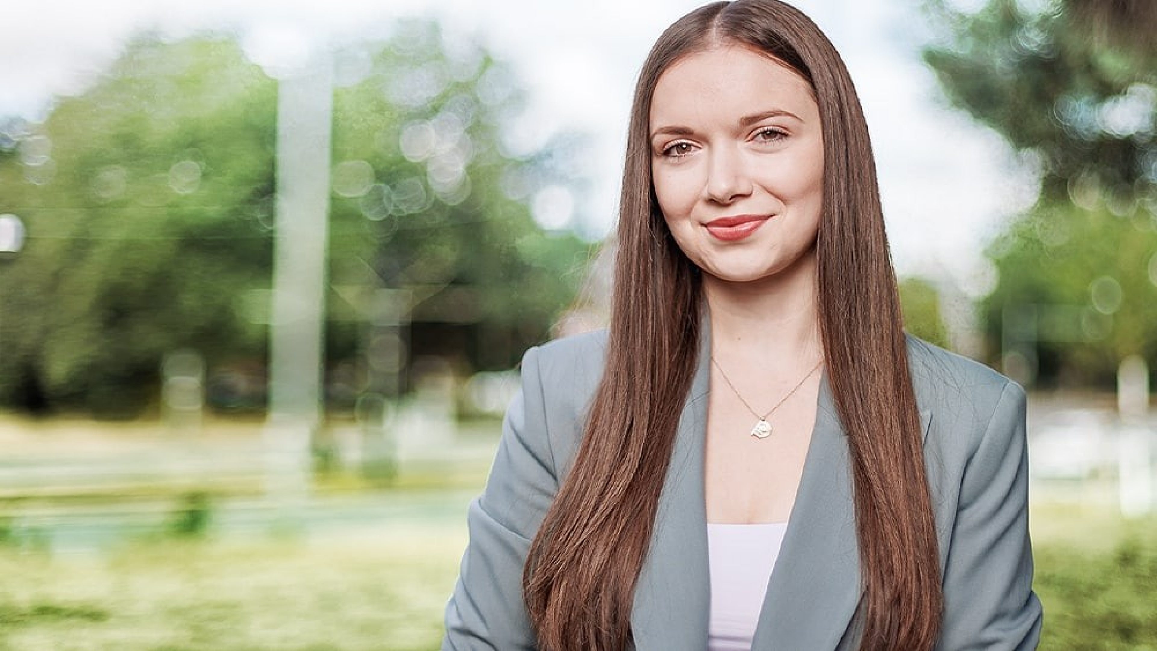 Student Blick in die Kamera an Wand lehnend