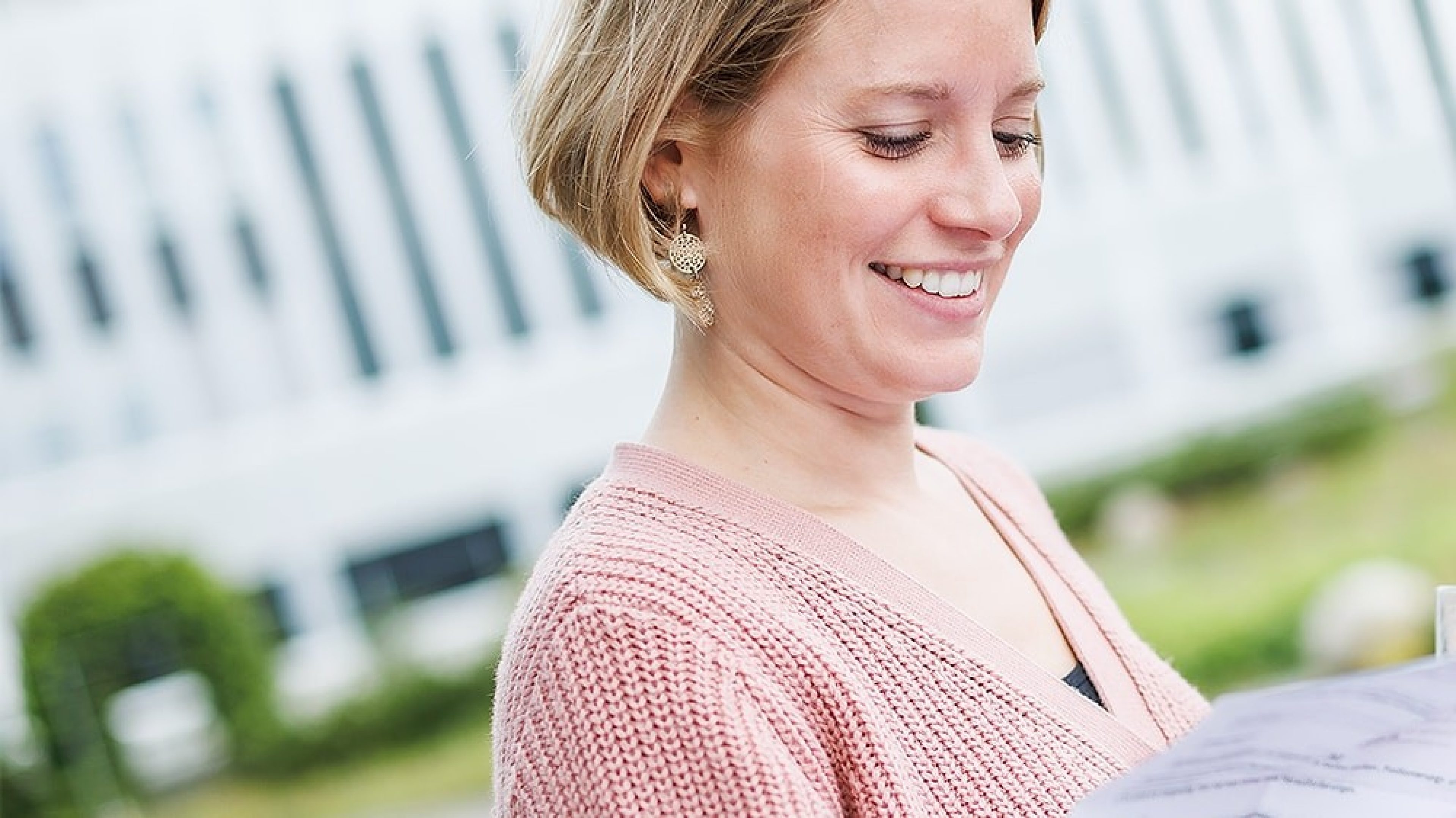 Junge Erwachsene in Berufskleidung Blick in die Kamera erklärt häufige Fragen zum Thema Bewerbung