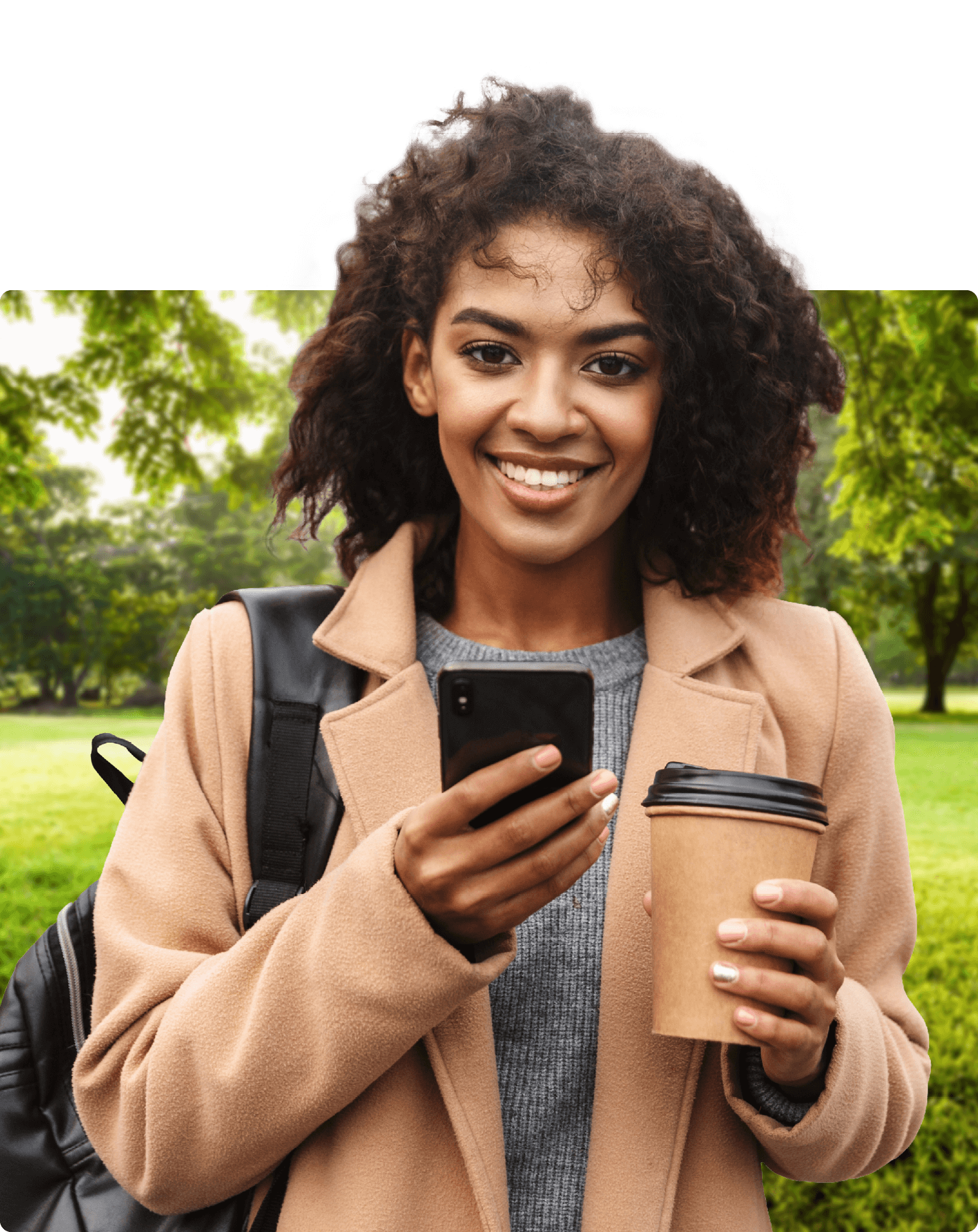 Junge Frau mit Kaffee und Handy in der Hand blickt in die Kamera 