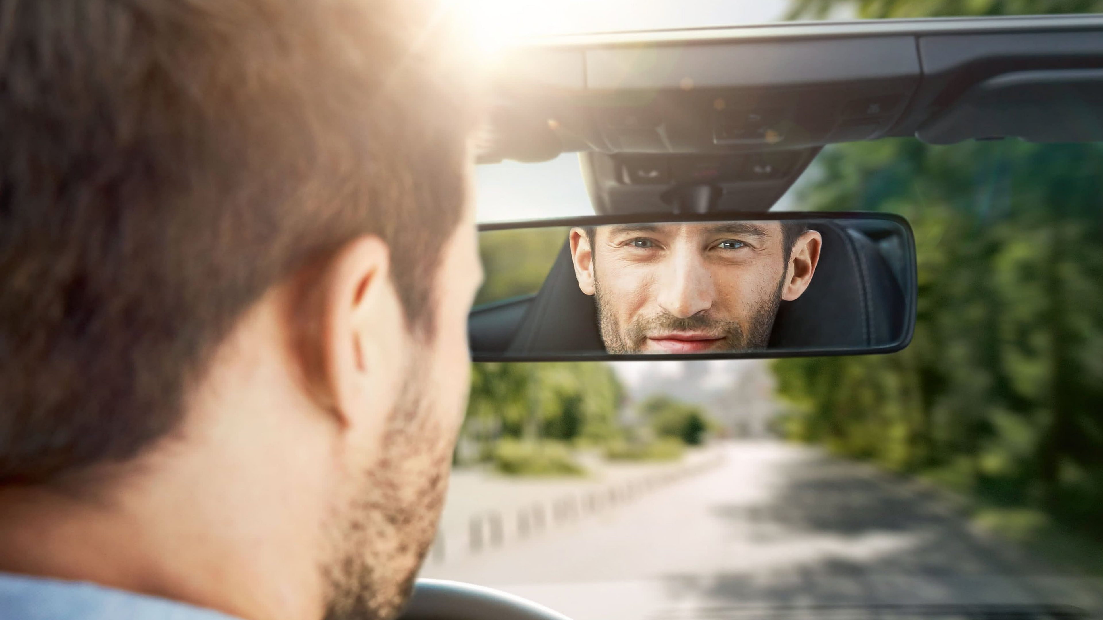 Autofahrer im Caprio schaut in den Rückspiegel