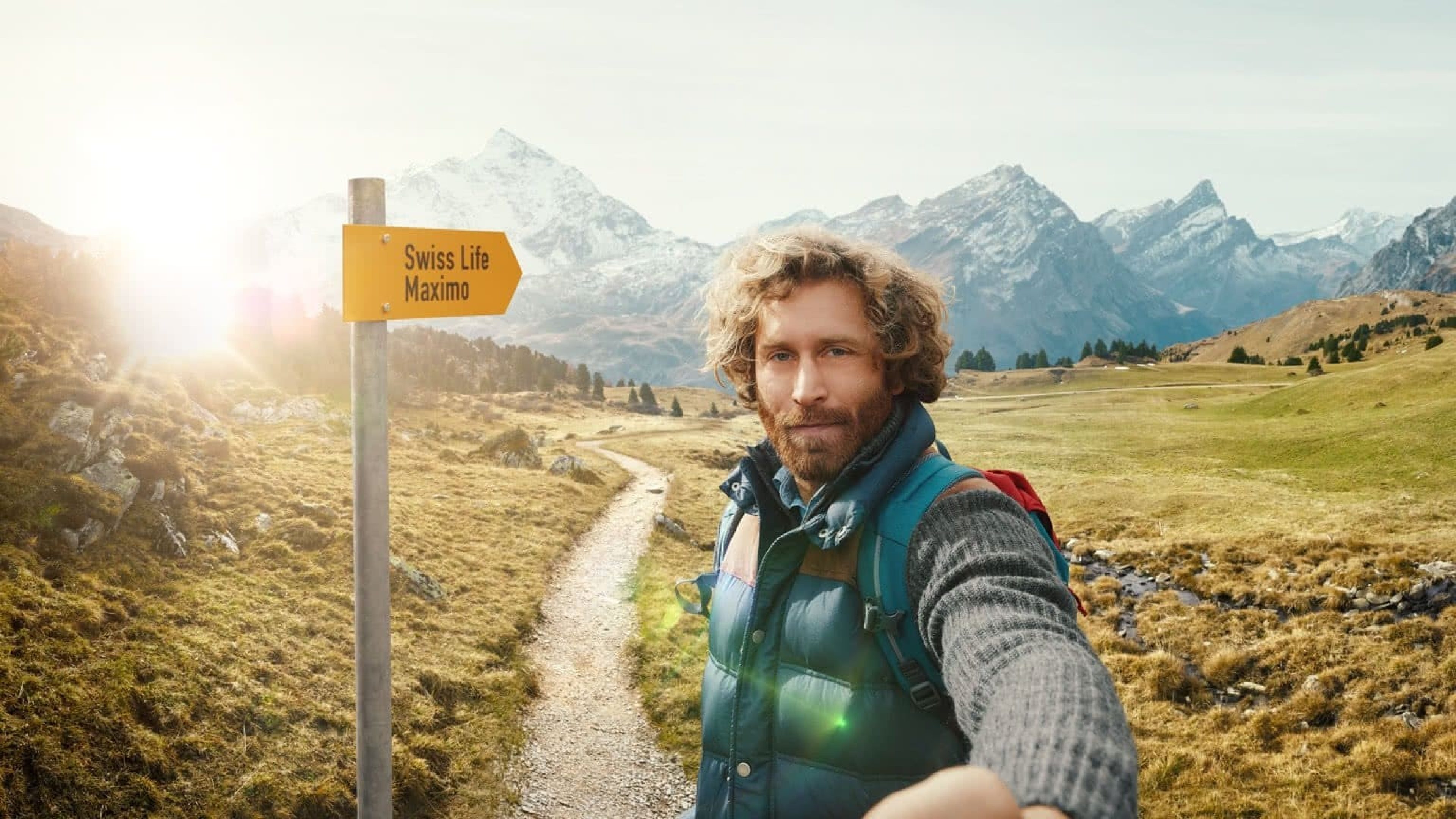 Junger Mann in den Schweizer Bergen im Hintergrund Wegweiser Swiss Life Maximo