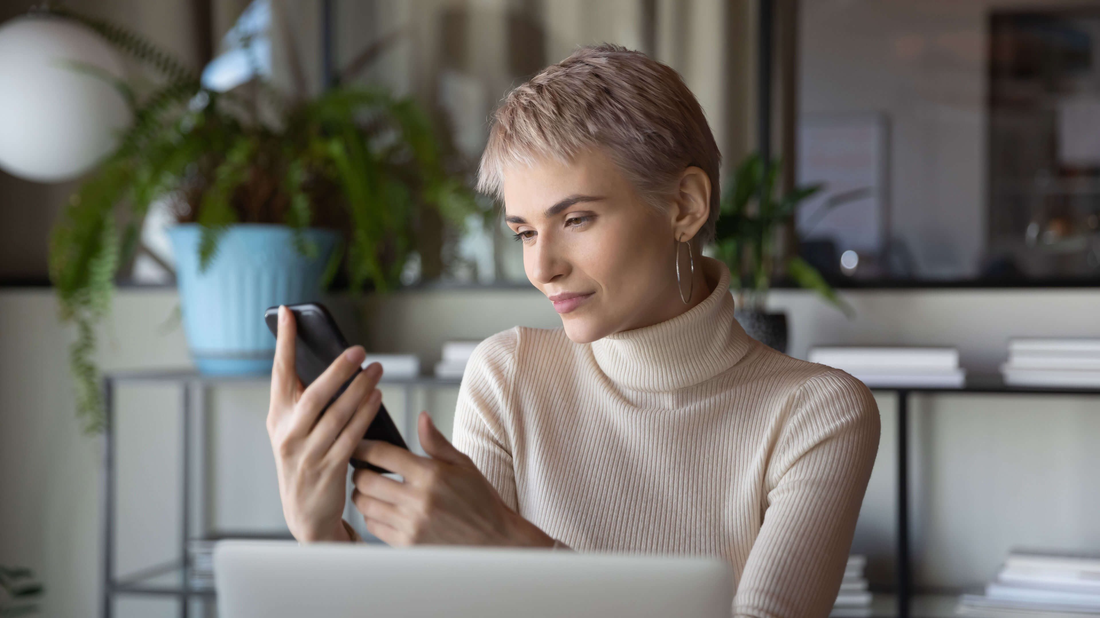 Frau mit Smartphone informiert sich über Irrtümer in der Altersvorsorge für Frauen