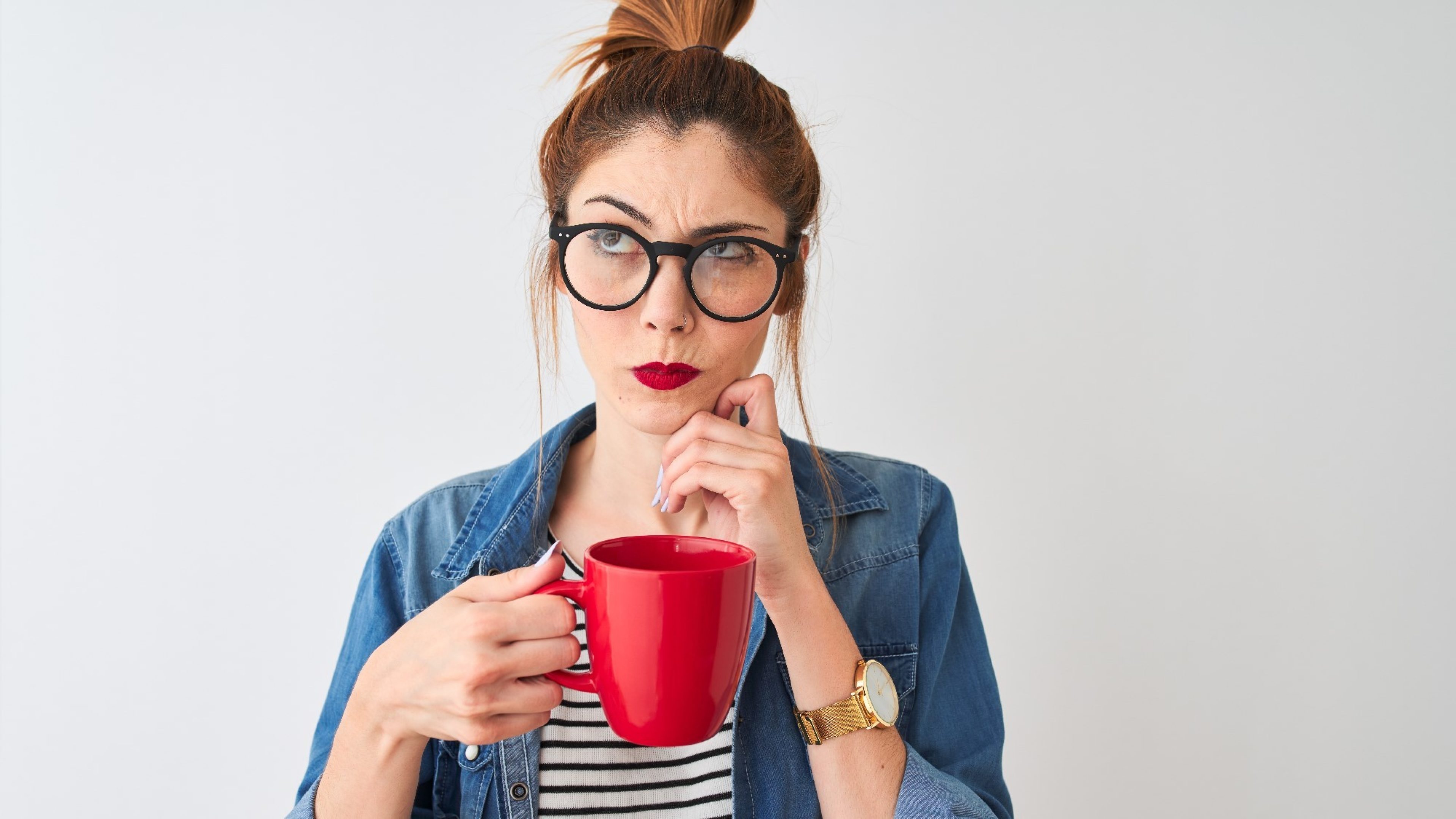 Nachdenkliche Frau mit Brille und Kaffeetasse