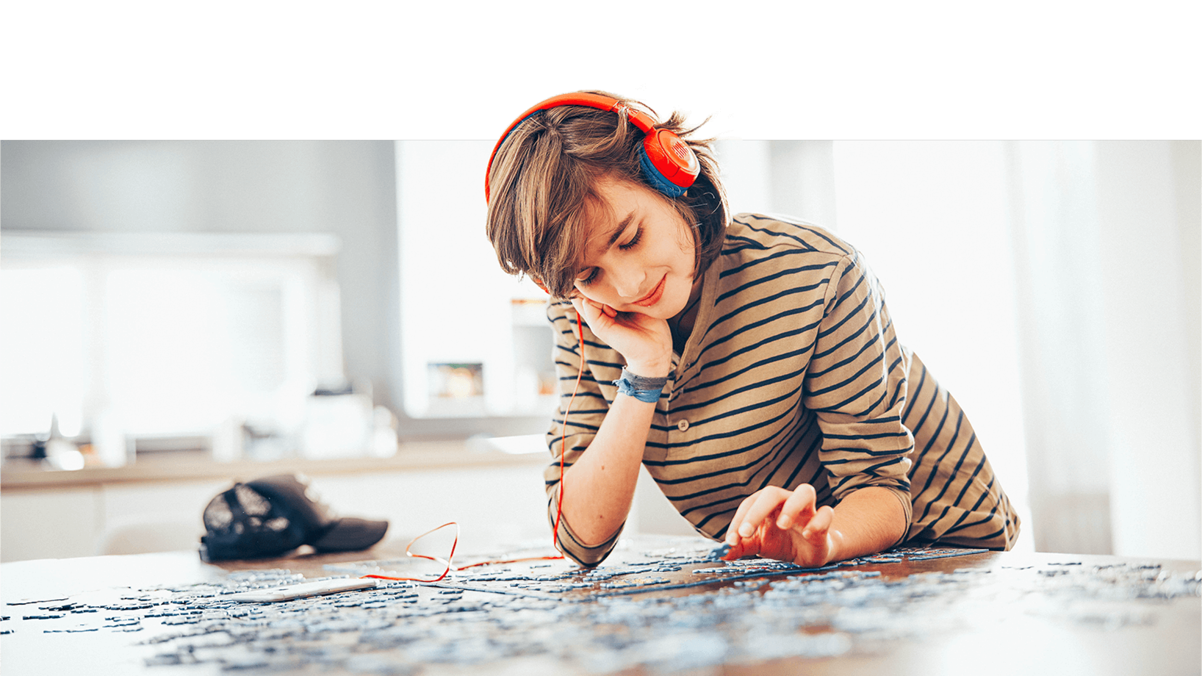 Schüler mit Kopfhörer beim Puzzeln