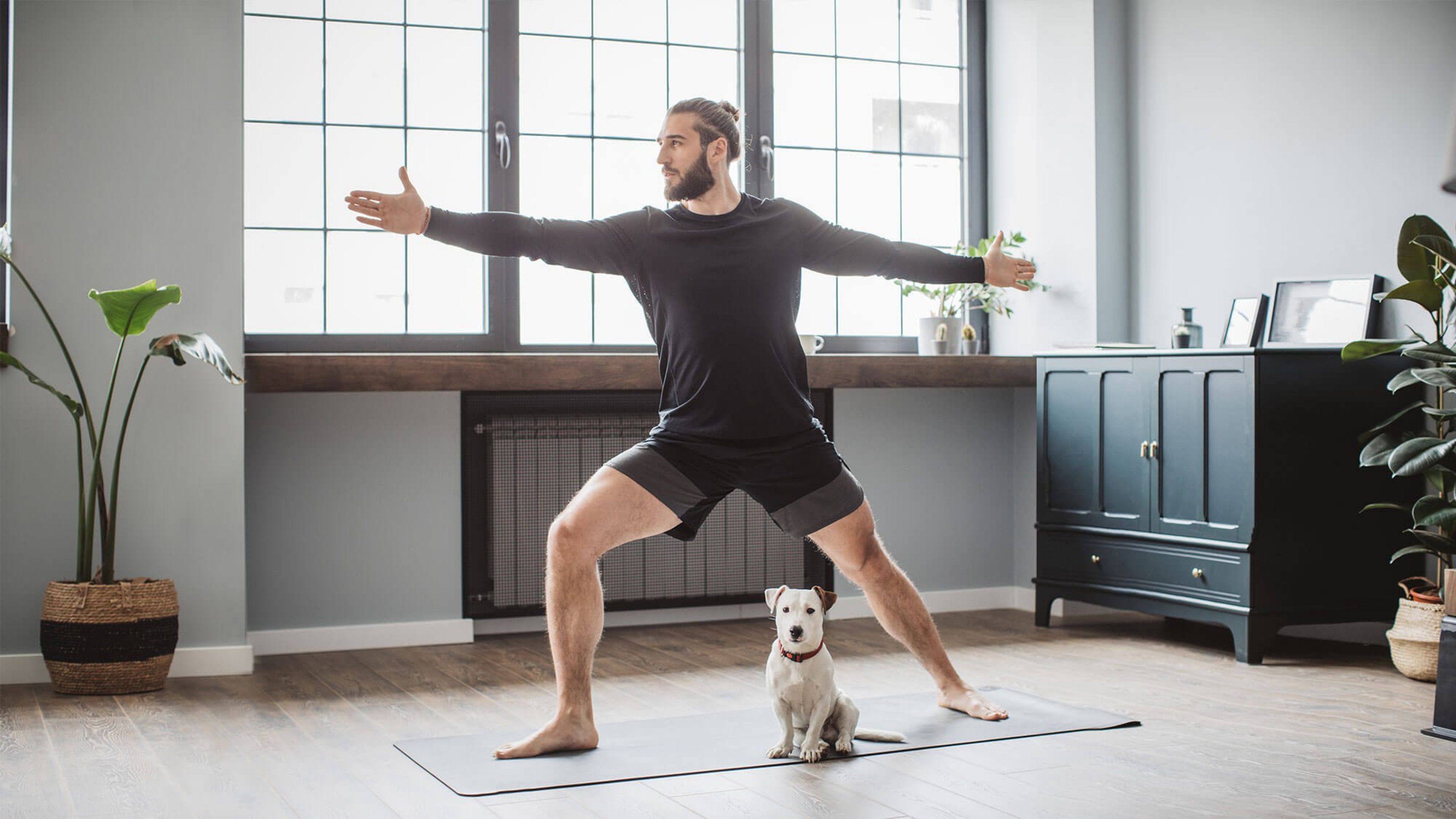 Mann mit Hund macht Yoga