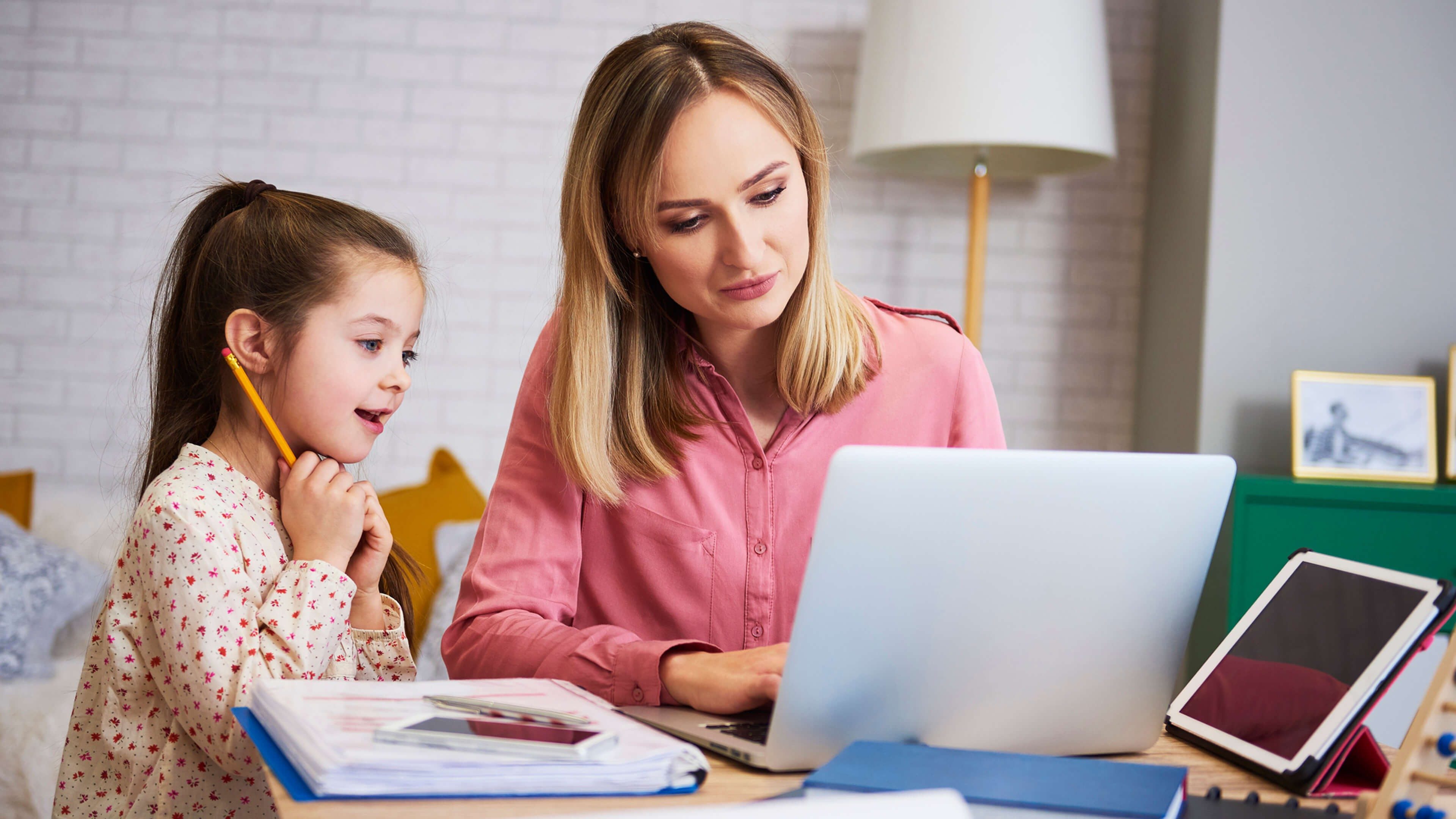 Mutter lernt mit ihrer Tochter am Schreibtisch