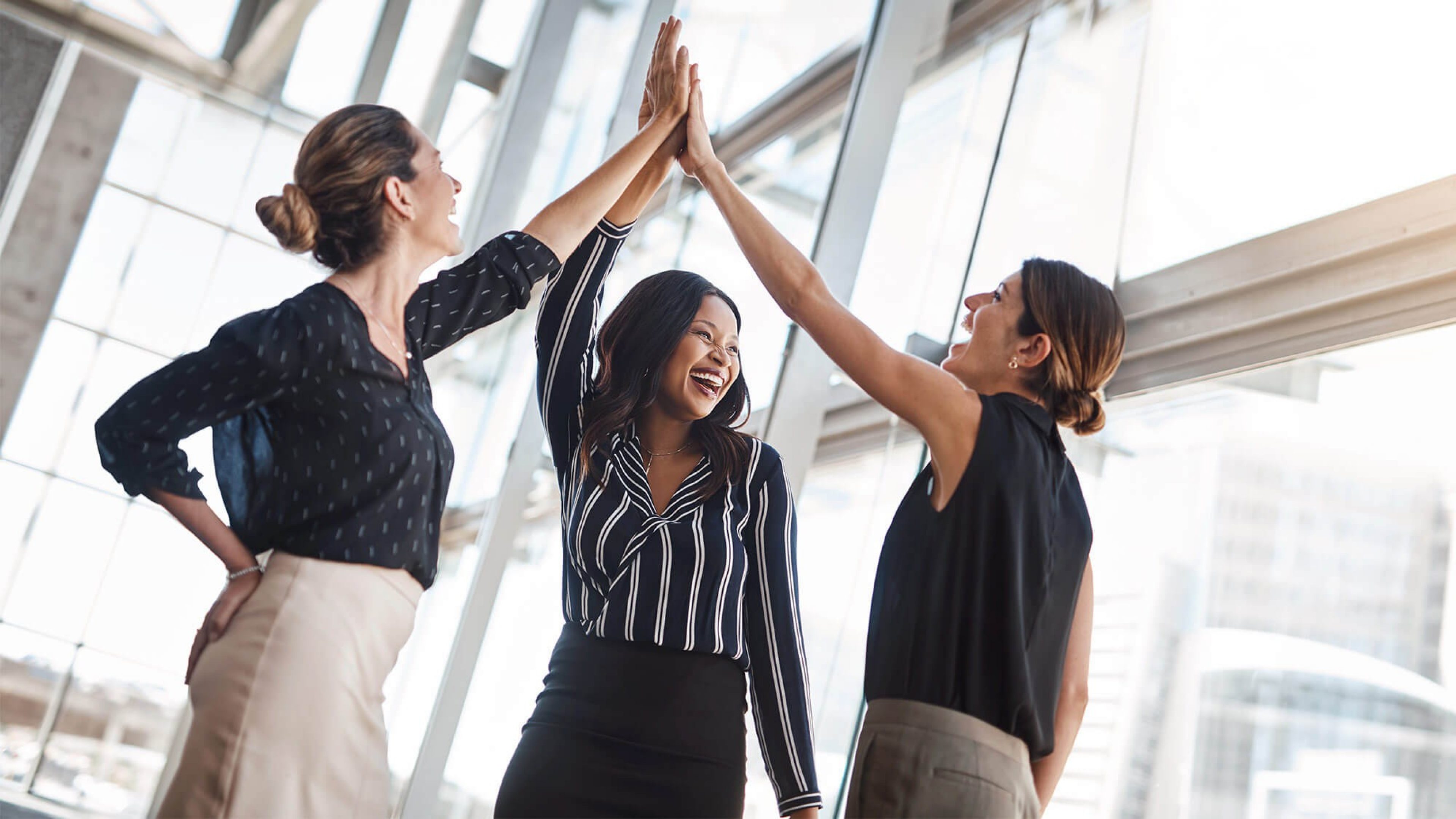 Drei Business-Frauen geben sich ein High Five