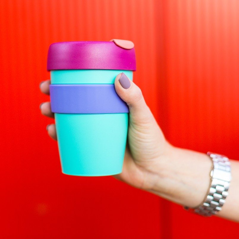 Frau hält bunten Becher in einer Hand