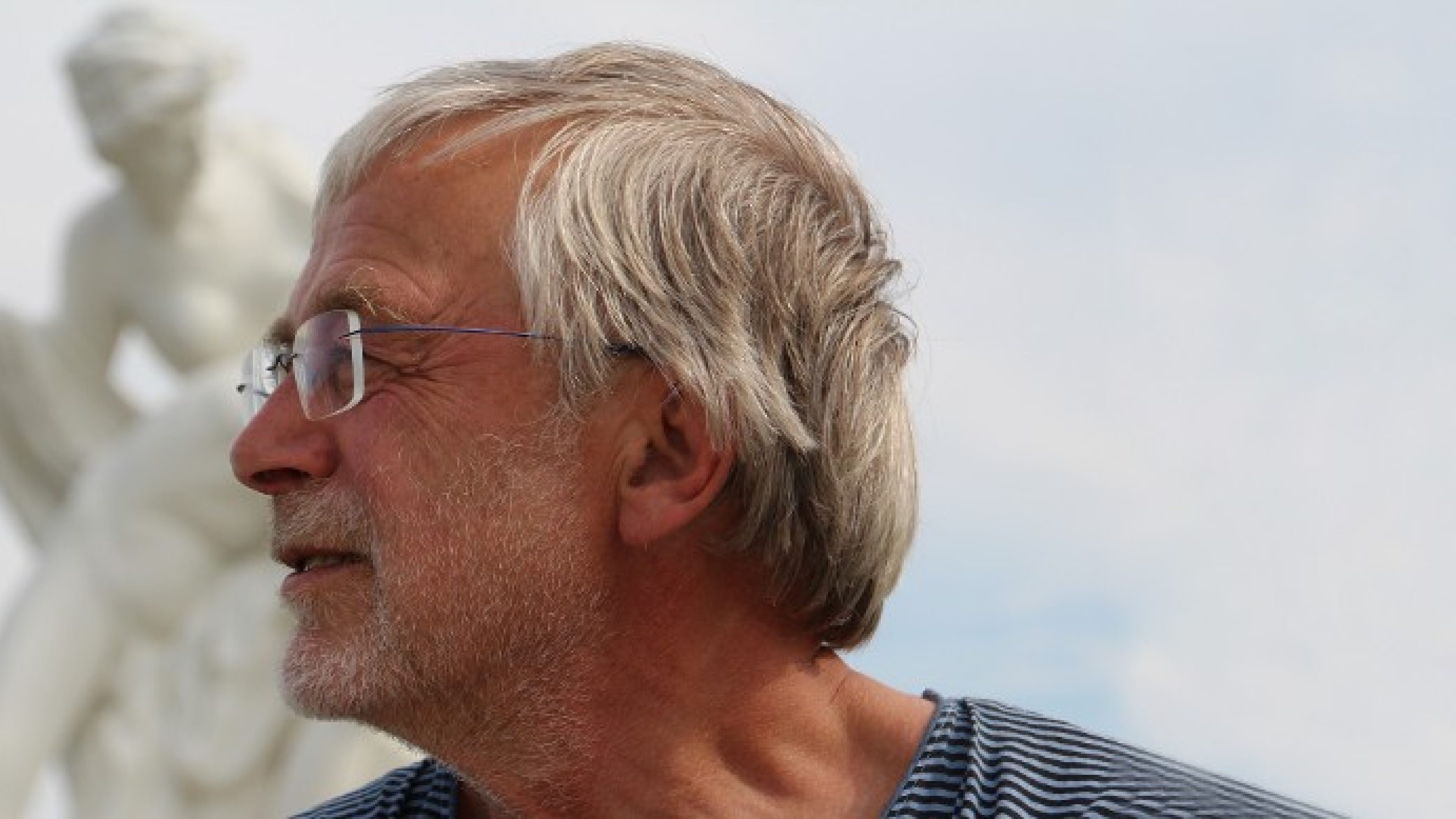 Prof. Dr. Gerald Hüther mit grauen Haaren und Brille blickt in die Ferne 