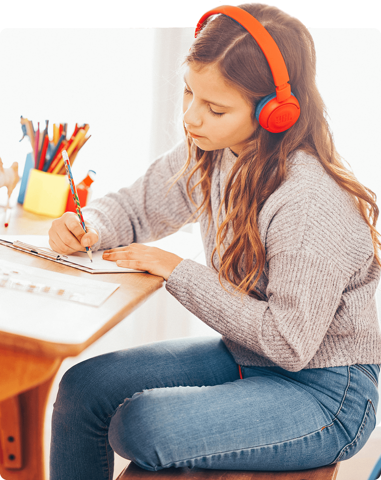 Schülerin mit roten Kopfhörern macht ihre Hausaufgaben