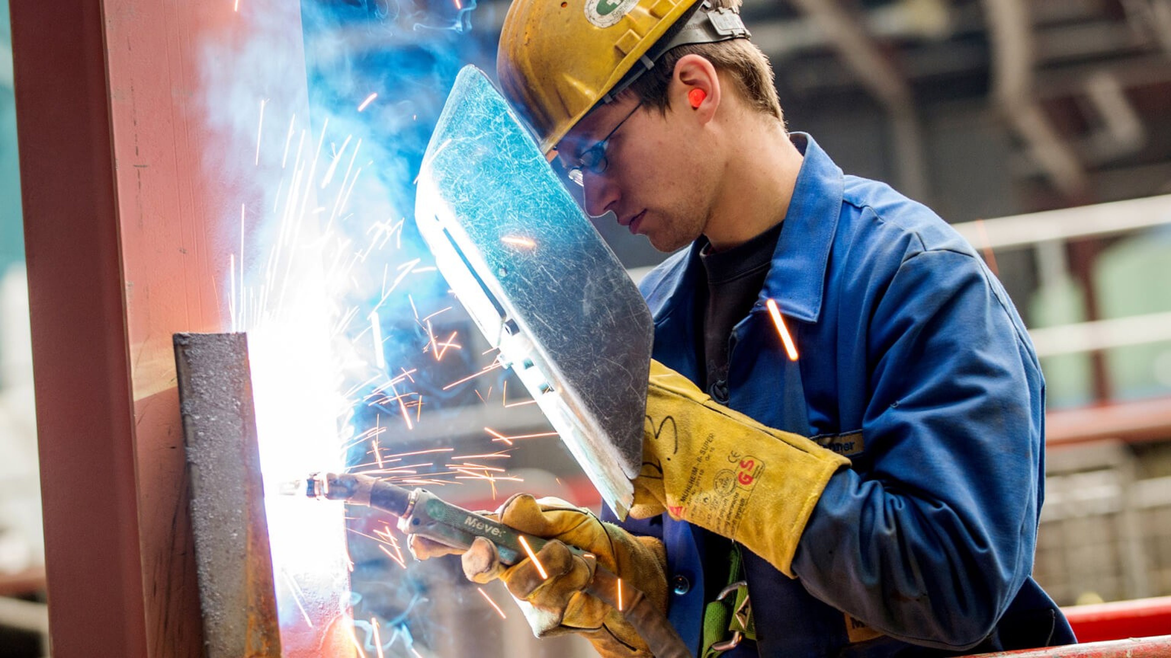 Zwei Arbeiter in einer Produktionshalle am Schweißen