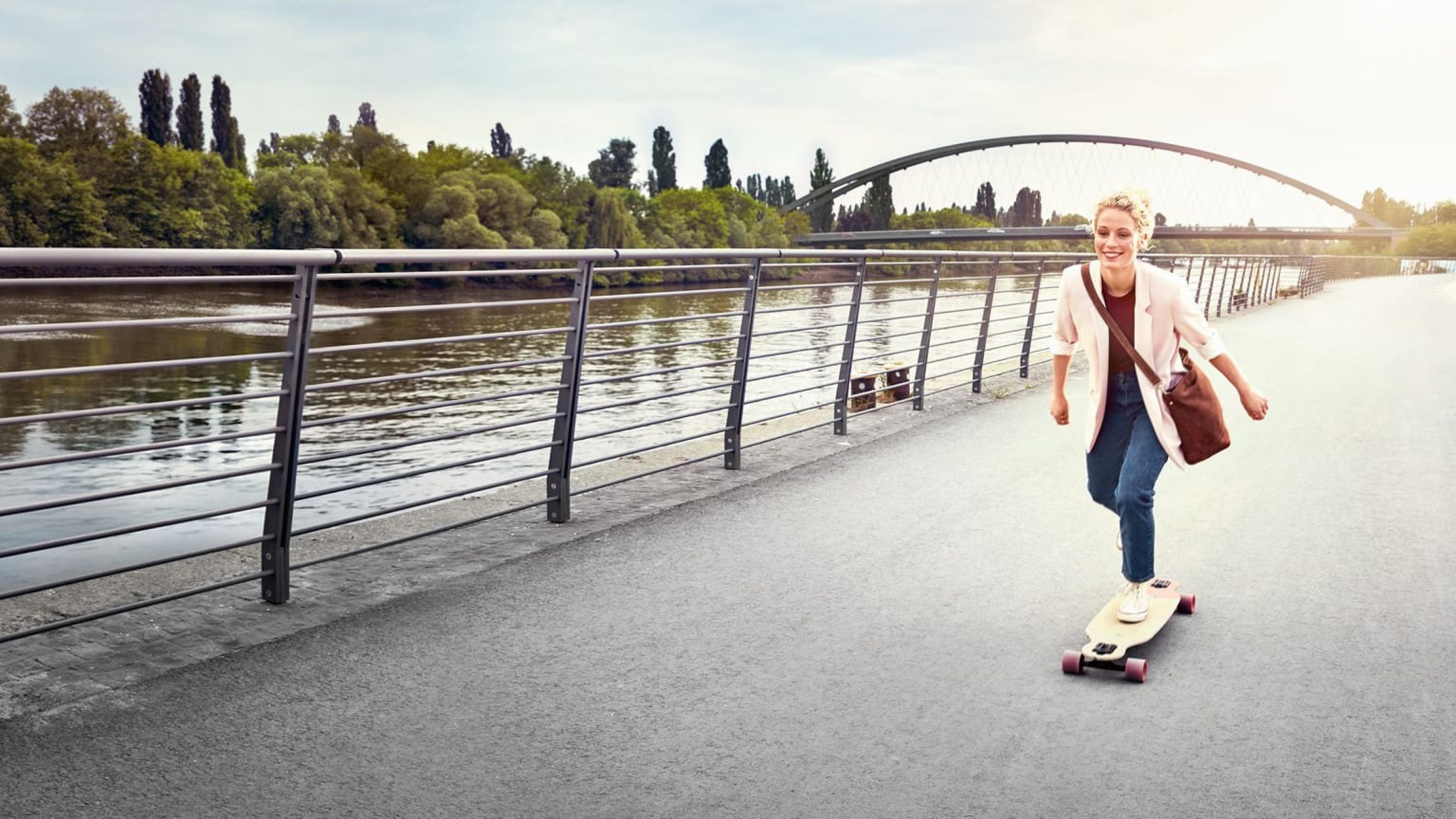 Frau auf Skateboard am Fluss