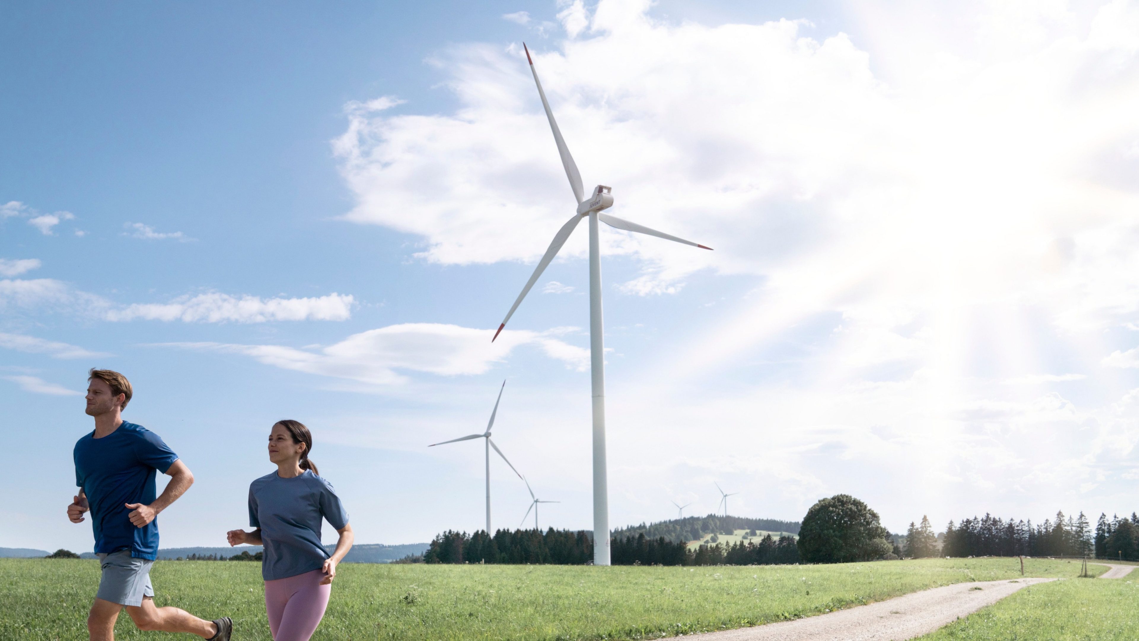 Jogger,  im Hintergrund Windräder