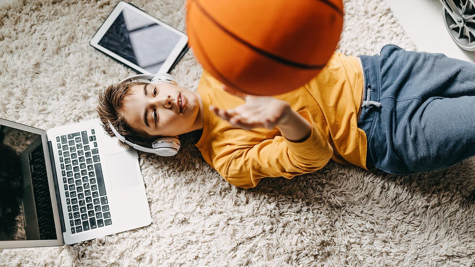 Ein Junge macht eine Pause vom Lernen und spielt mit seinem Ball