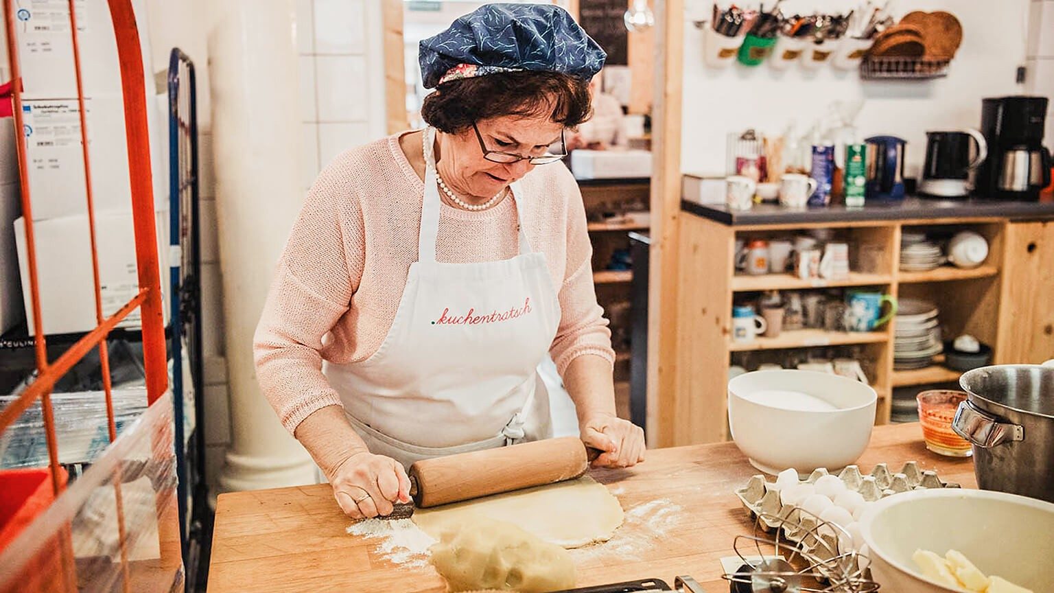 Eine Oma rollt Teig aus