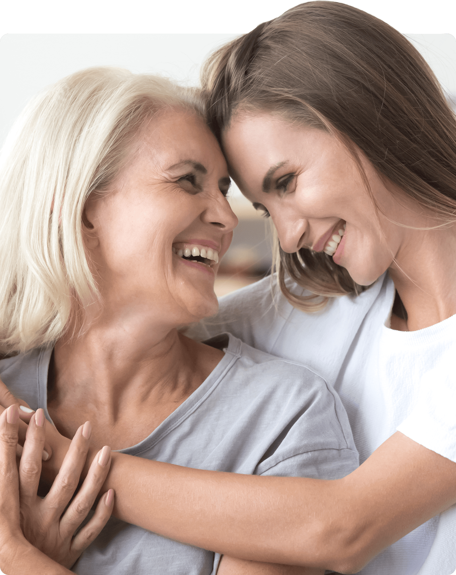 Mutter und Tochter nehmen sich in Arm und lachen sich an